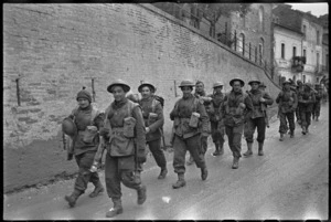 NZ Infantry formation passes through Italian village on way to front line on Christmas morning, World War II - Photograph taken by George Kaye