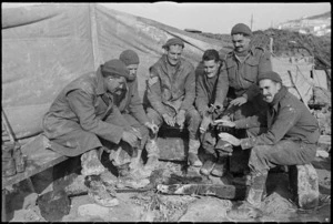 New Zealand gunners on the Italian Front attempting to warm themselves in the cold, World War II - Photograph taken by George Kaye