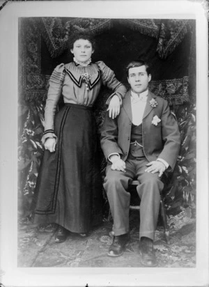 Unidentified man and woman, with a carpet draped in the background, probably Christchurch district