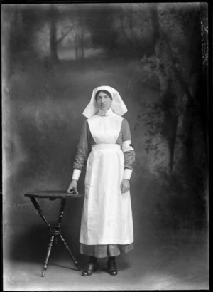 Studio portrait of unidentified female nurse, in a Red Cross uniform, probably Christchurch district