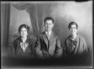 Head and shoulders studio portrait of an unidentified young man and two young women, shows bows on the women's dresses, probably Christchurch district