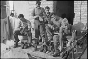 NZ PRS Field Section personnel removing mud from their boots, Italian Front, World War II - Photograph taken by George Kaye