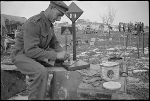 F J Andrews constructing and painting signs for use by NZ Division on the Italian Front, World War II - Photograph taken by George Kaye