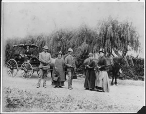 Group of people standing on a road by horses and a carriage