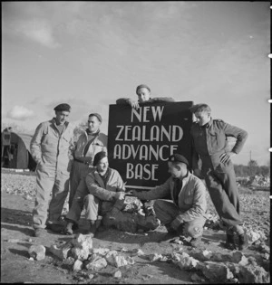 Group around notice at entrance to the New Zealand Advance Base Camp in Italy, World War II - Photograph taken by M D Elias