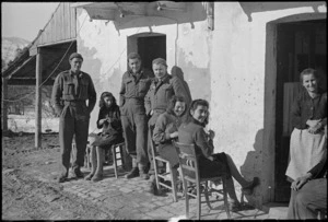 New Zealanders outside their temporary home with its civilian owners in an Italian village, World War II - Photograph taken by George Kaye
