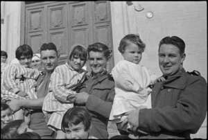 Three orphan children of Castelfrentano fraternizing with Kiwi soldiers, World War II - Photograph taken by George Kaye