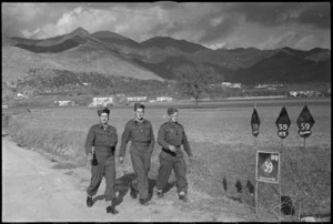 Soldiers walking near black diamond signs of the NZ Division in the Volturno Valley, Italy, World War II - Photograph taken by George Kaye
