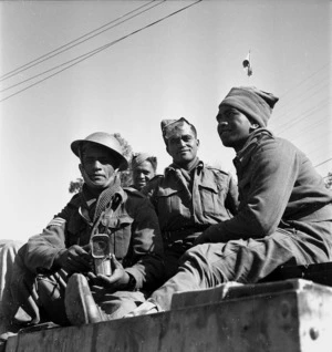 Paton, H, fl 1942 (Photographer) : Four unidentified soldiers of the Maori Battalion share a tin of bully beef in Tripoli, Libya