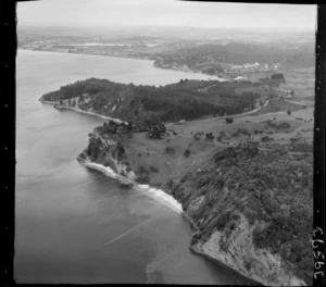 The Snow Rainger property on a headland with buildings, bush and steep cliffs, looking south to Hatfield's Beach settlement, North Auckland, with the Hibiscus Coastal Highway and the Waiwera Hill Scenic Reserve