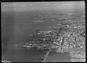 Ports of Auckland wharves and city centre with railway yards, with Tamaki Drive Bridge and the Royal Akarana Yacht Club Marina beyond, Auckland City