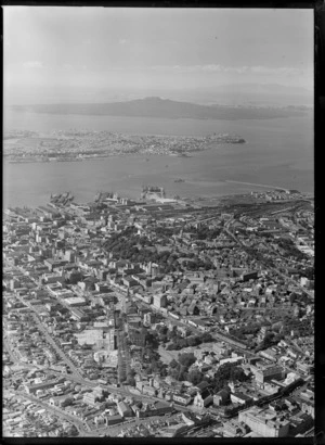 Auckland City with Queen Street, Albert Park, railway station and yards, to the Ports of Auckland wharves and harbour entrance beyond, Auckland