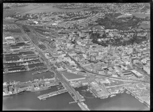 Ports of Auckland wharves with Quay Street and city centre, railway yards, Albert Park and Auckland Domain, with Tamaki Drive Bridge and Hobson Bay beyond, Auckland City