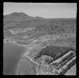 Large residential property with jetty and pine plantation at Rainbow Point, Lake Taupo, with Two Mile Bay, Lake Terrace road with housing developments and Mount Tauhara beyond