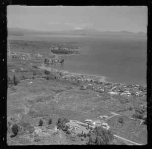 Lake Taupo shoreline with Lake Terrace and Waipahihi Bay with buildings and jetties, with Mount Ruapehu beyond
