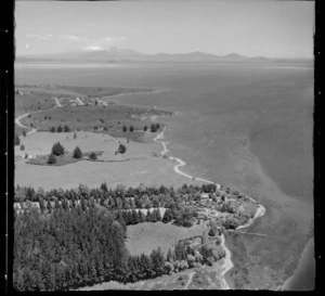 Large residential property with jetty and pine plantation at Rainbow Point, Lake Taupo, with Lake Terrace road, Wharewaka settlement and Mount Ruapehu beyond