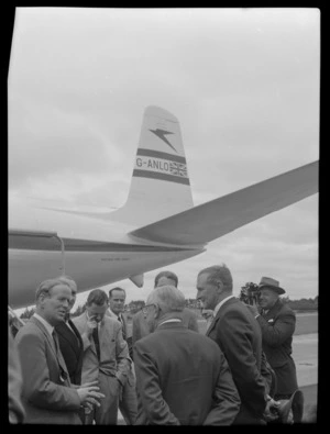 Mr Cunningham left and Mr T Shand right talking with unidentified men, with Comet G-ANLO aircraft behind, Whenuapai, Auckland Region