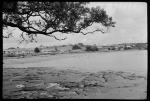 Tindalls Beach, Whangaparaoa Peninsula, shows people and houses along the beach