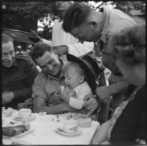 Corporal Phillipson and Private Win with baby at garden party for repatriated POWs, Gazira Sporting Club, Cairo