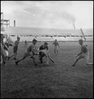 Play during a rugby football game between NZ Army Service Corps and a Royal Navy team in the Bari Stadium, Italy - Photograph taken by George Kaye