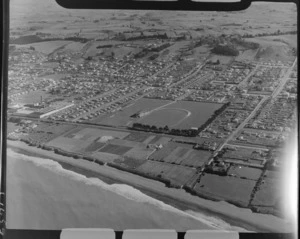 North Oamaru residential area with beach and railway line, rugby grounds and [freezing works or dairy?] factory in foreground with farmland beyond, Canterbury Region