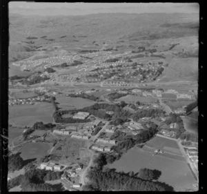 Porirua Hospital and School in foreground with the Johnsonville-Porirua Motorway in the valley below, looking to Mungavin Avenue and Porirua East beyond, Wellington Region