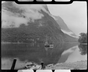 Milford Sound with two fishing boats moored in foreground with Mitre Peak enclosed by cloud beyond, Fiordland National Park, Southland Region