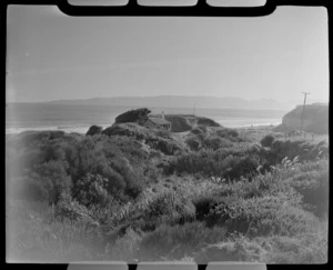 View of a beach cottage among the scrub covered dunes in front of Te Waewae Bay, Orepuki, Southland Region