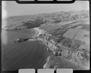 Phonolite Cobble Beach and headland with railway line in foreground, with Purakaunui Bay with Purakaunui Inlet beyond, Waitati, Otago Region