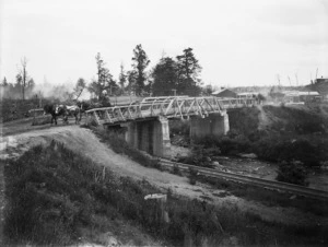 Scene at a bridge in Ohakune showing wood being transported by horse and cart from Gamman & Co sawmill
