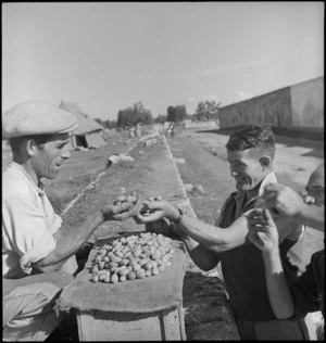 R M Griffin makes a small purchase of almonds near Taranto, Italy, World War II - Photograph taken by George Kaye