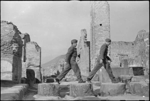 Two Kiwi soldiers negotiating stepping stones in a street in Pompei, Italy, World War II - Photograph taken by George Kaye