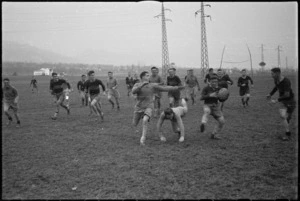 Members of NZ Public Relations Service play rugby football in rain and mud behind the lines, Italian Front, World War II - Photograph taken by George Kaye