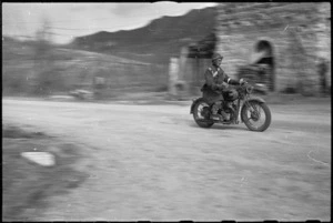 Dispatch rider B J Beasley, Maori Battalion, passes at speed on 5th Army Front, Italy, World War II - Photograph taken by George Kaye