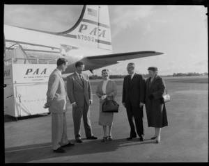 Four unidentified men with an unidentified Pan American World Airways female model in front of PAA N79012 aeroplane, Whenuapai Airport, Waitakere, Auckland city