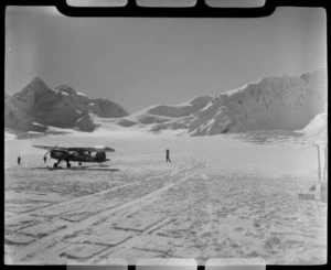 Mount Cook Air Services Auster ZK-BLZ Ski Plane and three unidentified people at the head of the Tasman Glacier with snow covered mountains beyond, Mount Cook National Park, Canterbury Region