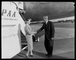 Unidentified Pan American World Airways model being greeted by an older man in front of PAA aeroplane, Whenuapai Airport, Waitakere, Auckland city