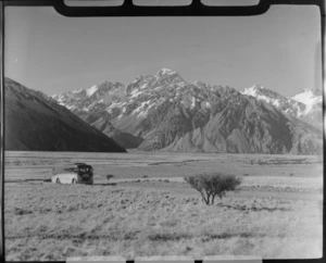 Mount Cook and Southern Lakes Tourist Coach on the Mount Cook Road with snow covered mountains beyond, Mackenzie Basin, Canterbury Region