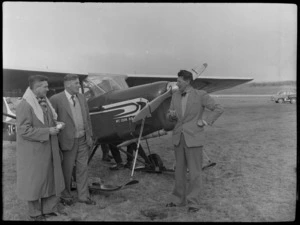 Three unidentified men with a Mount Cook Air Services Ltd aircraft, Mount Cook Airfield, Mount Cook National Park, Canterbury Region, during the preparation for the Antarctic Expedition