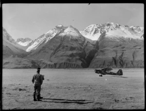 Mount Cook Air Services Ltd, Auster aircraft NZ-1707 and two unidentified men during the preparation for the Antarctic Expedition, Mount Cook Airfield, Mount Cook National Park, Canterbury Region