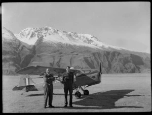 Two unidentified men with a Mount Cook Air Services Ltd, Auster aircraft NZ-1707, Mount Cook Airfield, Mount Cook National Park, Canterbury Region, during the preparation for the Antarctic Expedition
