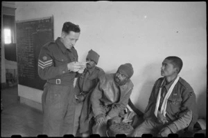 British staff sergeant checks medical cards for Indian army patients at English hospital in Caserta, Italy, World War II - Photograph taken by George Bull
