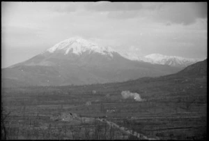 Enemy shell bursts on road in the Monte Cassino area with Monte Cairo in the background, Italy, World War II - Photograph taken by George Kaye