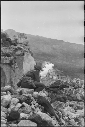 New Zealand Infantryman throwing a smokescreen around village in the Monte Cassino area, Italy, World War II - Photograph taken by George Kaye
