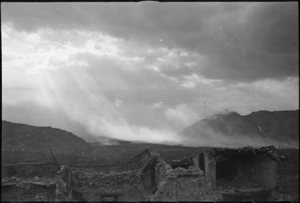 Sunlight breaking through clouds over Cassino lightens up smoke screen laid down following bombing, Italy, World War II - Photograph taken by George Kaye