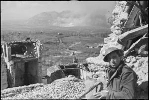 Photographer M D Elias observing the results of the bombing raid on Cassino, Italy, World War II - Photograph taken by George Kaye