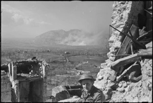 George Kaye, NZ Official Photographer, in the forward areas during bombing raid on Cassino, Italy, World War II - Photograph taken by M D Elias