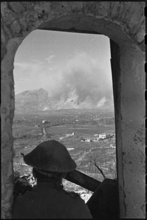 New Zealand observer silhouetted against the Monte Cassino battle area, Italy, World War II - Photograph taken by George Kaye