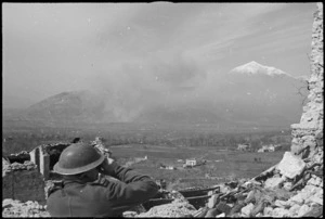 A New Zealander observing the combined bombing and shelling attack on Cassino, Italy, World War II - Photograph taken by George Kaye