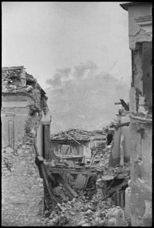Behind ruined buildings of Cevaro smoke rises from the bombs bursting on Cassino, Italy, World War II - Photograph taken by George Kaye